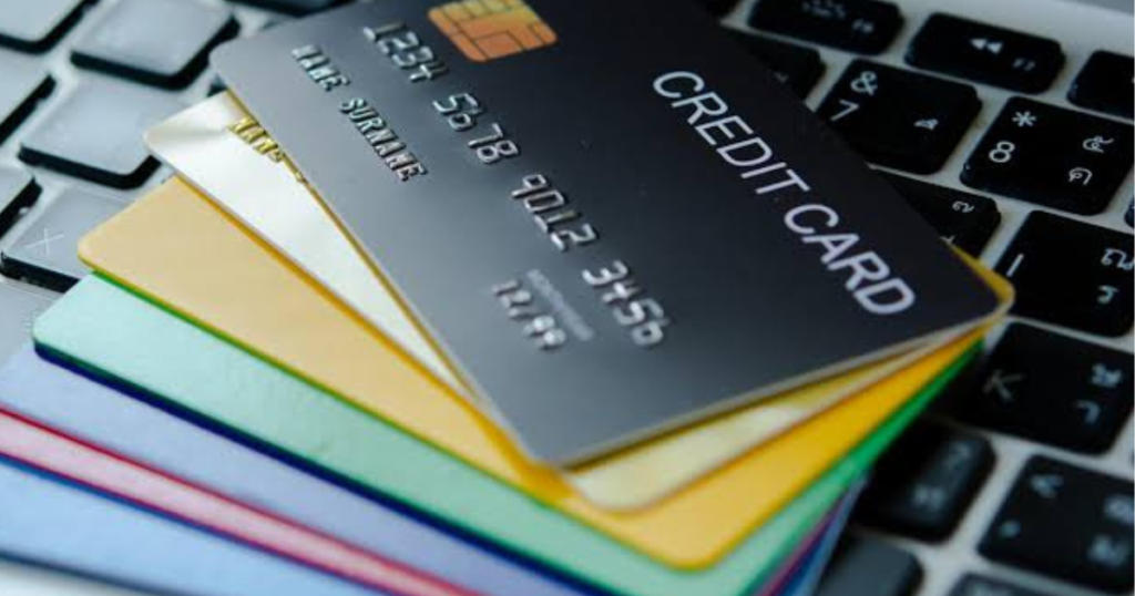 An illustration comparing a blue debit card paying a POS terminal versus a gold credit card at an ATM in the UK.